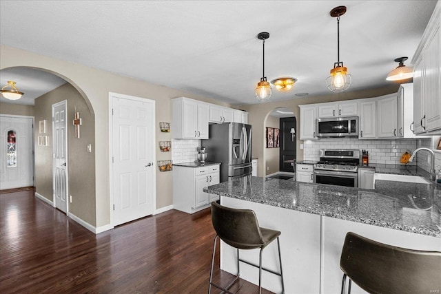 kitchen with white cabinetry, sink, decorative backsplash, and stainless steel appliances