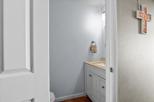 bathroom with vanity, hardwood / wood-style flooring, and toilet