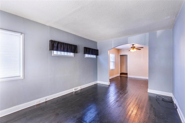 empty room featuring ceiling fan, dark hardwood / wood-style floors, and a textured ceiling