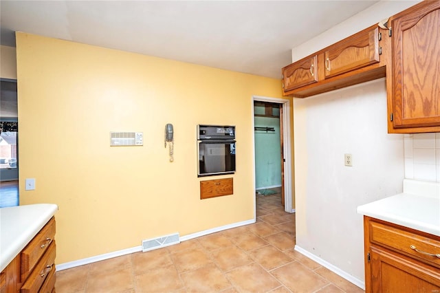 kitchen featuring tasteful backsplash and oven