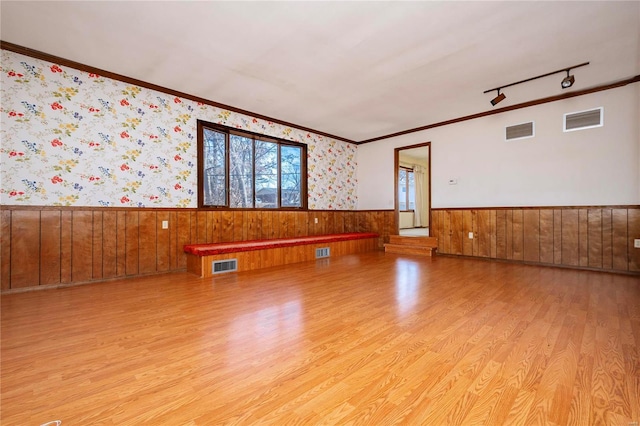 unfurnished room featuring ornamental molding and light hardwood / wood-style flooring