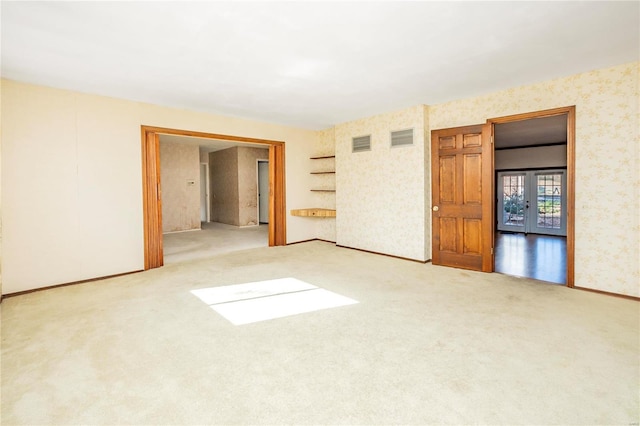 spare room with carpet flooring and french doors