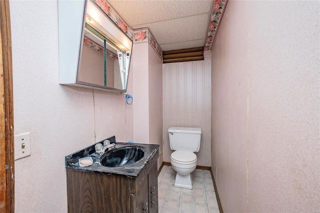 bathroom with vanity, a drop ceiling, and toilet