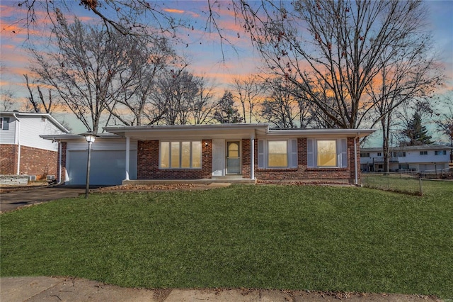 single story home with a garage and a yard