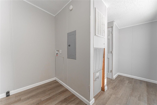 hallway featuring crown molding, electric panel, a textured ceiling, and light wood-type flooring