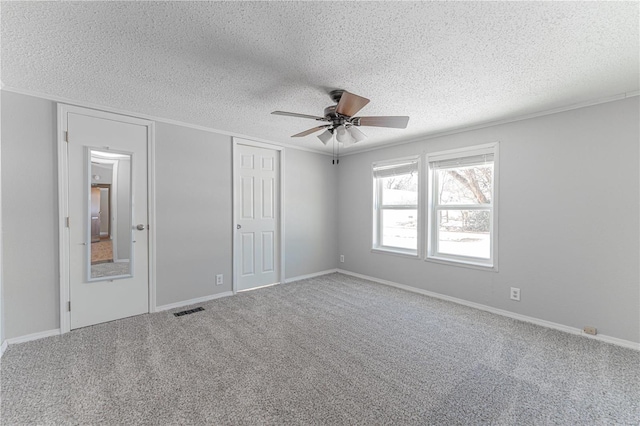 unfurnished bedroom featuring carpet floors, ornamental molding, and a textured ceiling