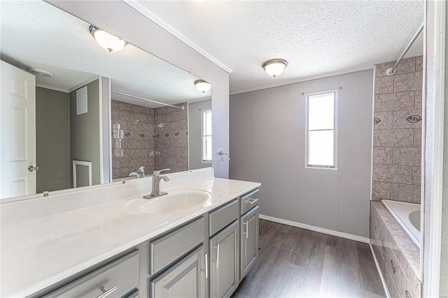 bathroom featuring vanity, tiled shower / bath combo, wood-type flooring, and a healthy amount of sunlight