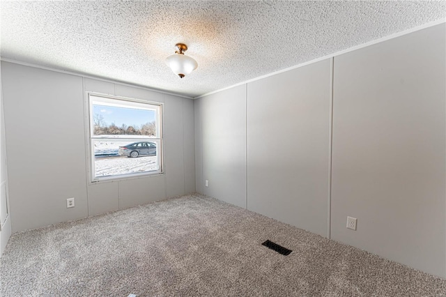 carpeted spare room with a textured ceiling