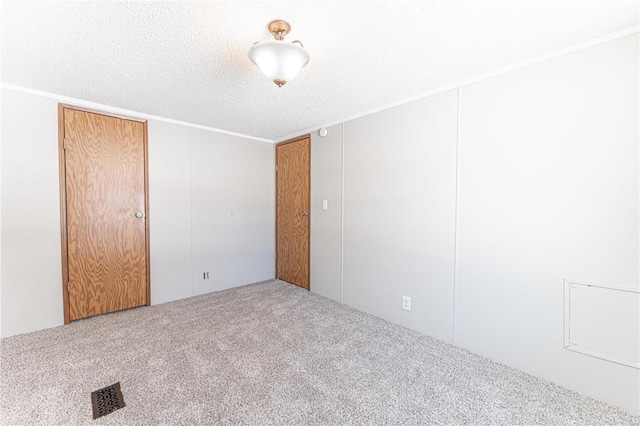 carpeted empty room with a textured ceiling