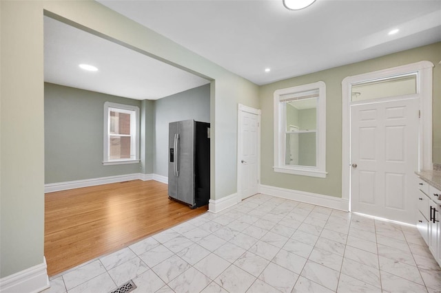 empty room featuring recessed lighting, marble finish floor, and baseboards