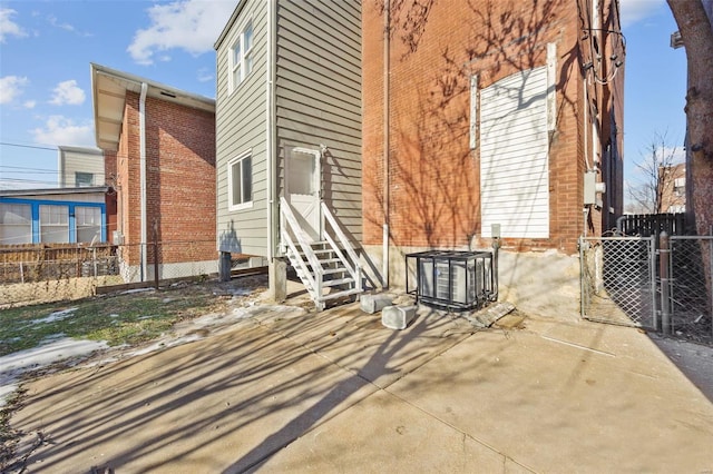 view of home's exterior featuring entry steps, central AC unit, a gate, and fence