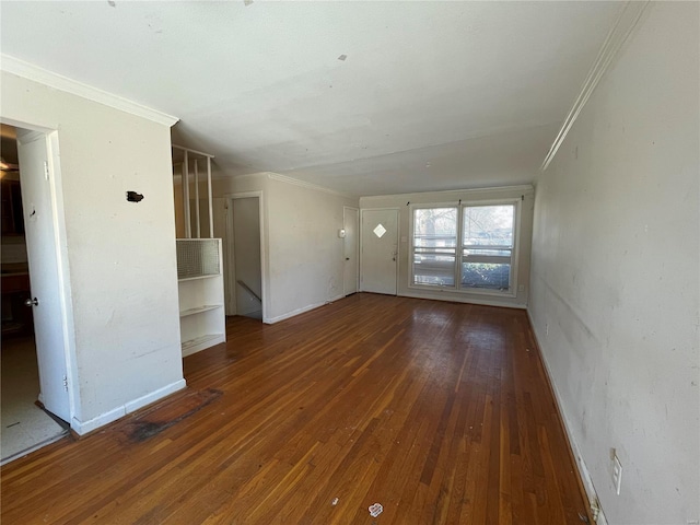 unfurnished living room with baseboards, hardwood / wood-style floors, and crown molding