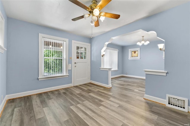 entryway featuring ceiling fan with notable chandelier and light wood-type flooring