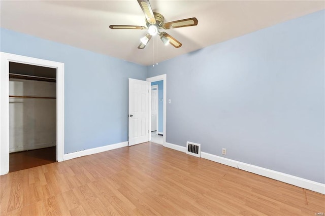 unfurnished bedroom featuring ceiling fan, a closet, and light wood-type flooring