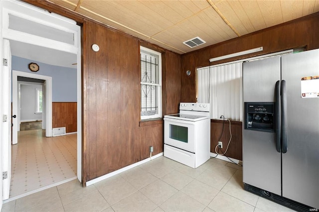 kitchen with wood ceiling, wooden walls, stainless steel fridge, and white electric range oven