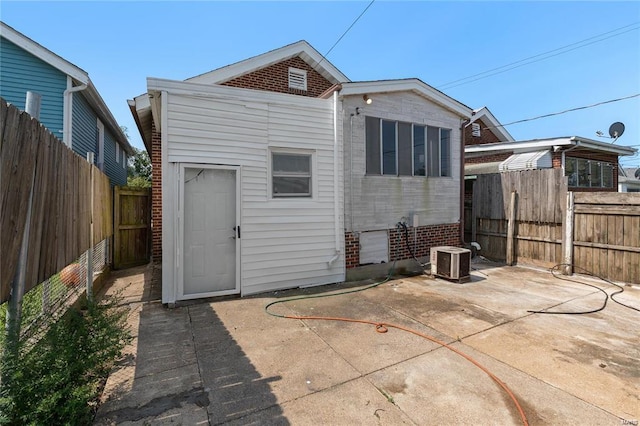 back of property with cooling unit and a patio area