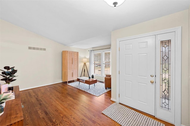 foyer featuring vaulted ceiling and dark hardwood / wood-style floors