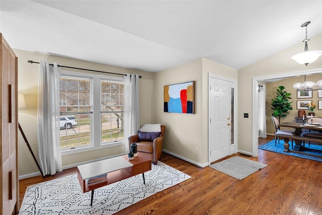 sitting room featuring a chandelier, wood-type flooring, and lofted ceiling