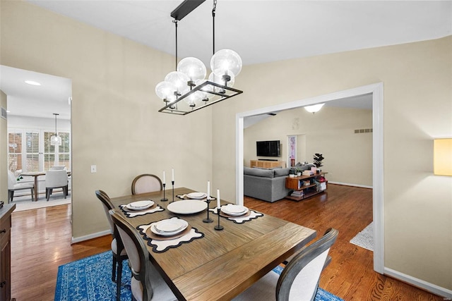 dining space featuring hardwood / wood-style floors and a notable chandelier