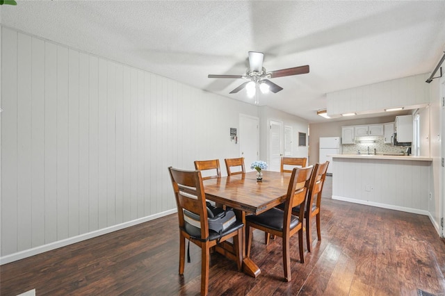 dining space with ceiling fan, dark hardwood / wood-style floors, and a textured ceiling