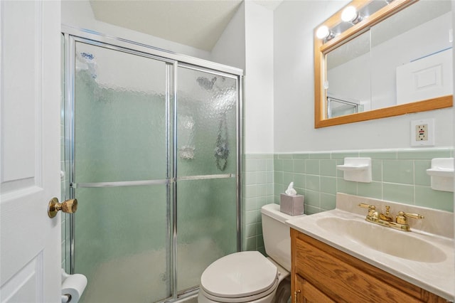 bathroom featuring vanity, a shower with shower door, tile walls, and toilet