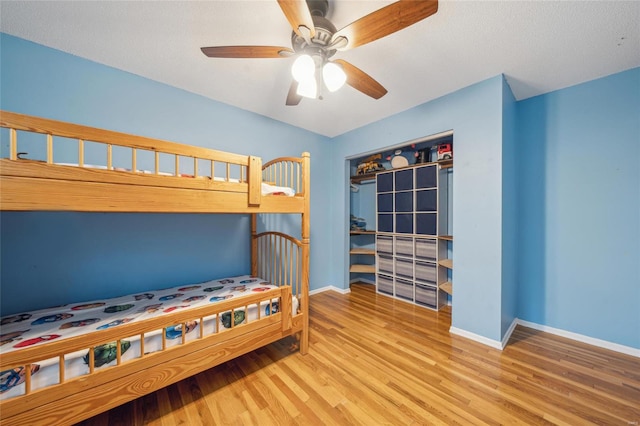 bedroom with light hardwood / wood-style flooring, a closet, and ceiling fan