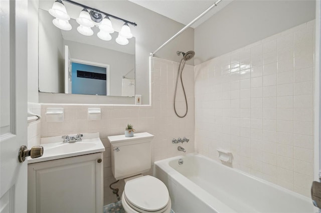 full bathroom featuring vanity, tiled shower / bath combo, tile walls, and toilet