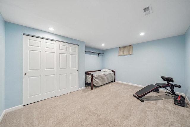 bedroom featuring light colored carpet and a closet