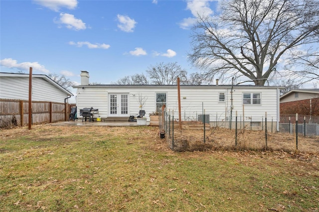 back of property featuring french doors, a yard, and a patio area