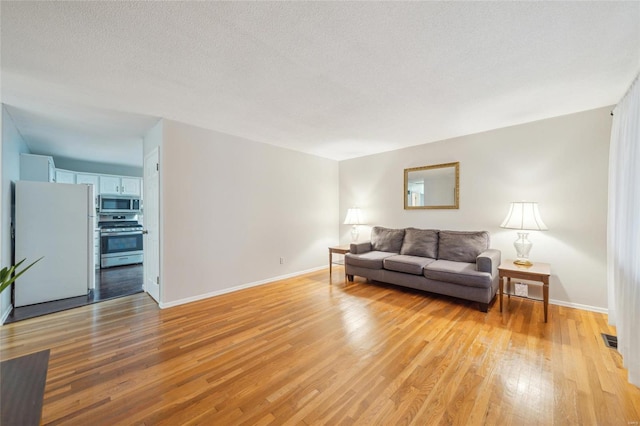 living room featuring light hardwood / wood-style floors and a textured ceiling