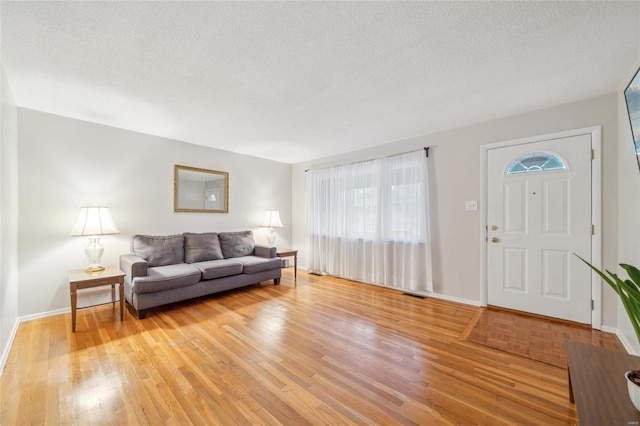 foyer entrance featuring a textured ceiling and light wood-type flooring