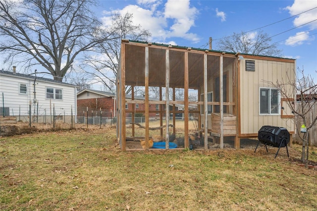 rear view of property with an outbuilding and a lawn