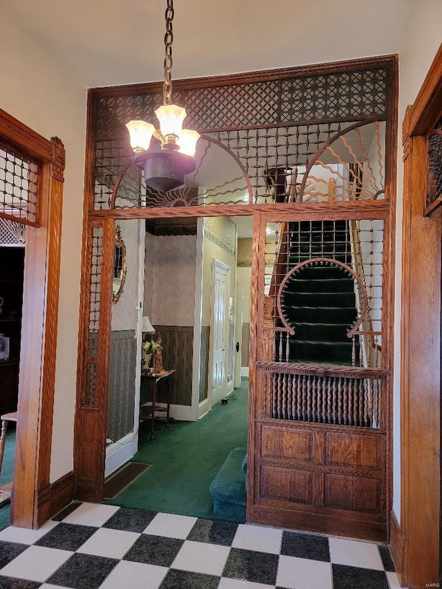 interior space featuring dark colored carpet and a notable chandelier