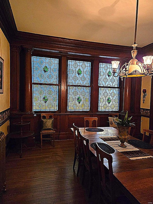 dining area featuring ornamental molding and dark hardwood / wood-style flooring