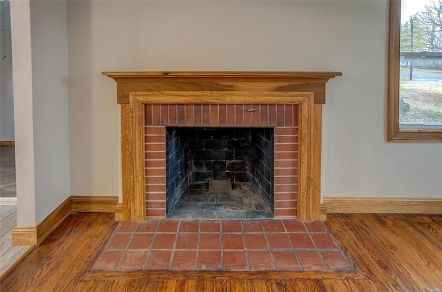 interior details featuring hardwood / wood-style flooring and a brick fireplace