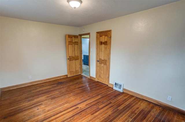 unfurnished room featuring dark hardwood / wood-style floors and a textured ceiling