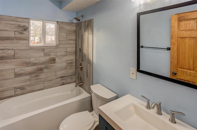 full bathroom featuring tiled shower / bath combo, vanity, and toilet