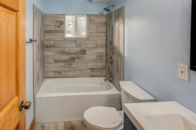 full bathroom with tiled shower / bath combo, vanity, and toilet