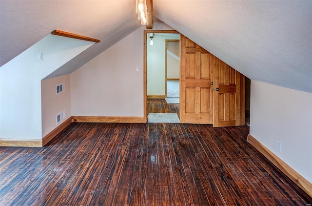 additional living space featuring vaulted ceiling and dark hardwood / wood-style floors