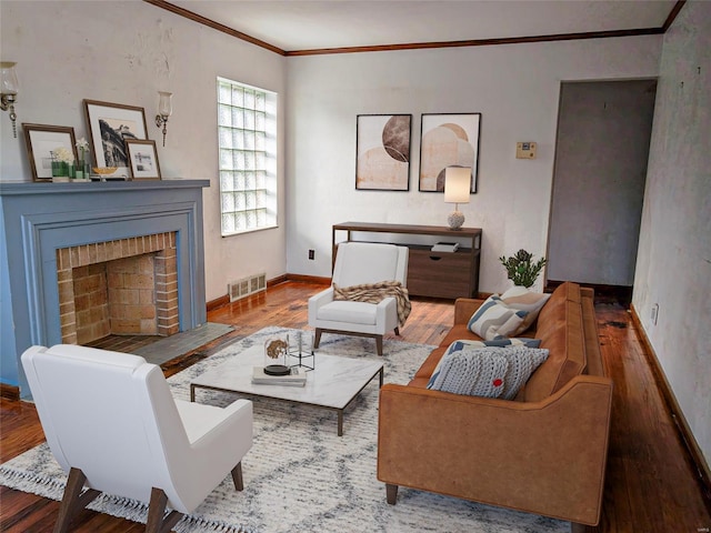 living room with crown molding, a fireplace, and hardwood / wood-style floors