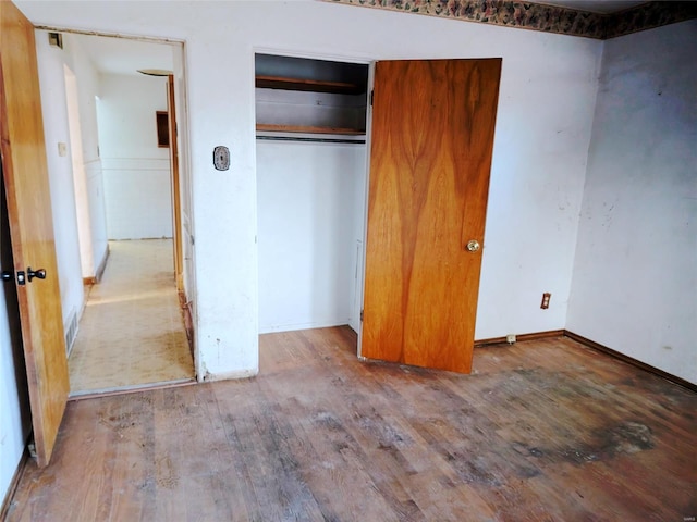 unfurnished bedroom featuring wood-type flooring and a closet