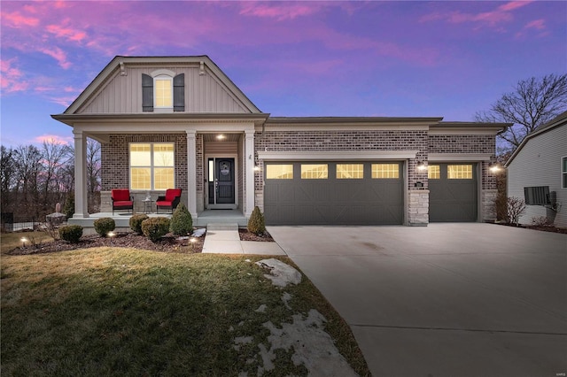 view of front of home featuring an attached garage, driveway, a porch, and brick siding