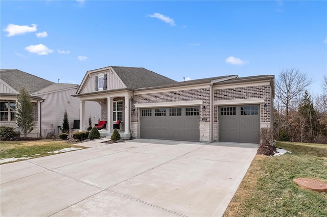 view of front of house with brick siding, a porch, an attached garage, driveway, and a front lawn