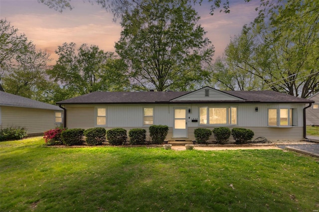 ranch-style house with a lawn and entry steps