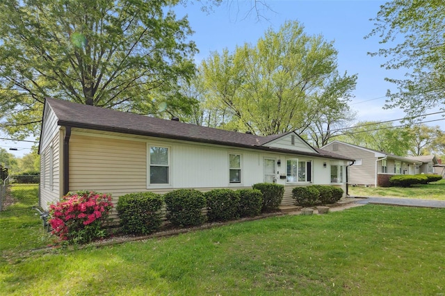 single story home with fence and a front lawn