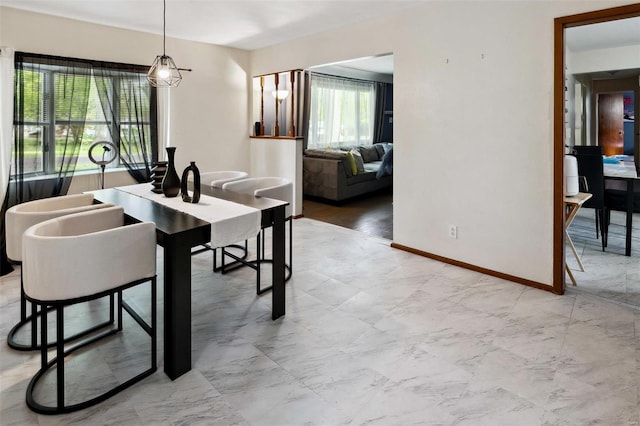 dining area featuring a wealth of natural light, marble finish floor, and baseboards