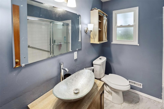 bathroom featuring visible vents, a stall shower, baseboards, toilet, and vanity