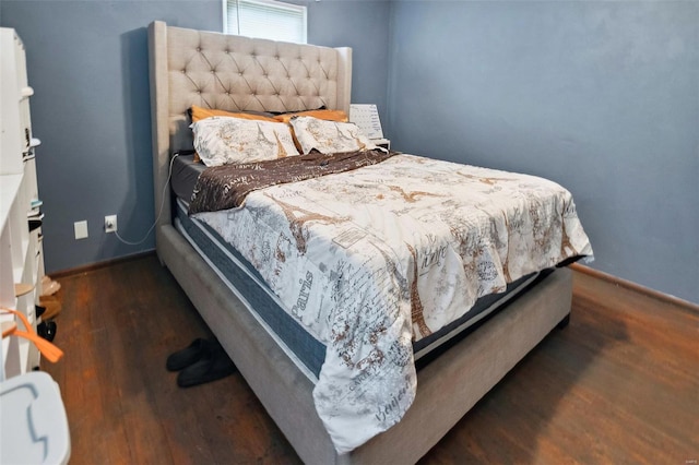 bedroom with baseboards and wood finished floors