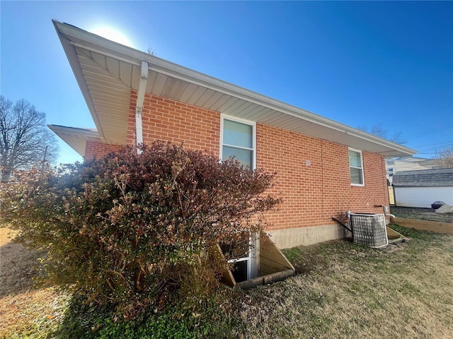 view of side of home with a yard and central air condition unit