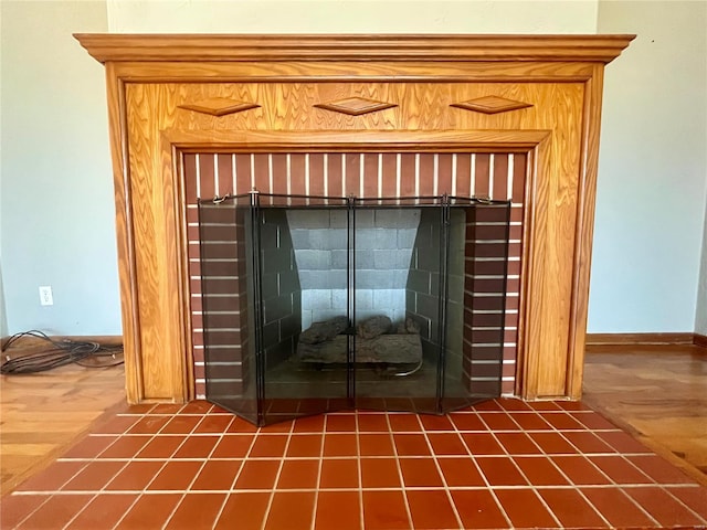 room details featuring a brick fireplace and hardwood / wood-style flooring